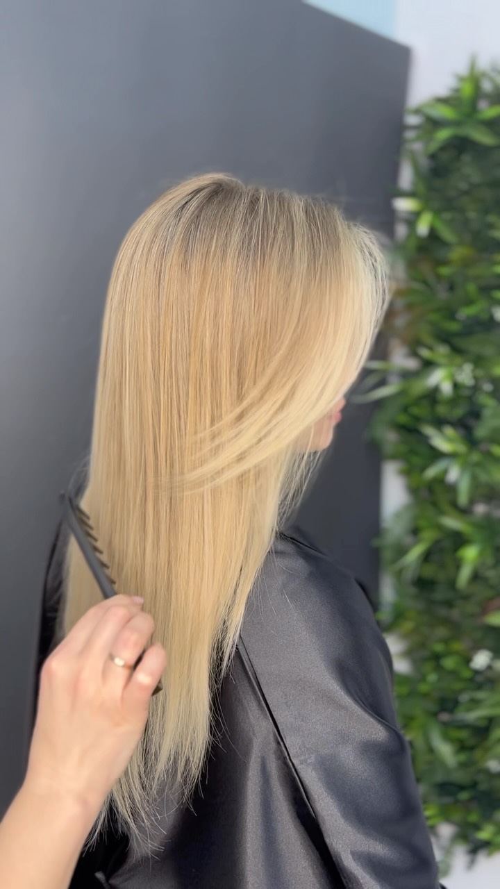 Kadeřnice češe vlasy po blond barvení