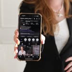 Klientka drží telefon s profilem studia na Instagramu